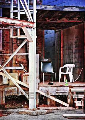 Three empry chairs outside an old factory